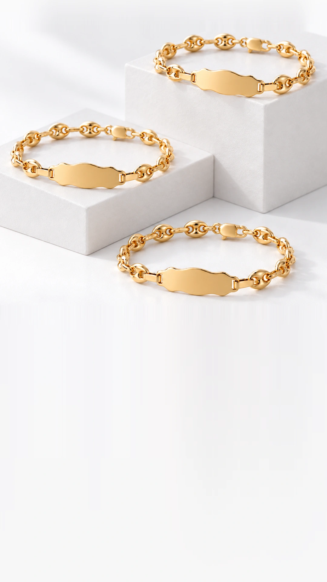 Tres esclavas de oro sobre cubos blancos, con placas para personalizar