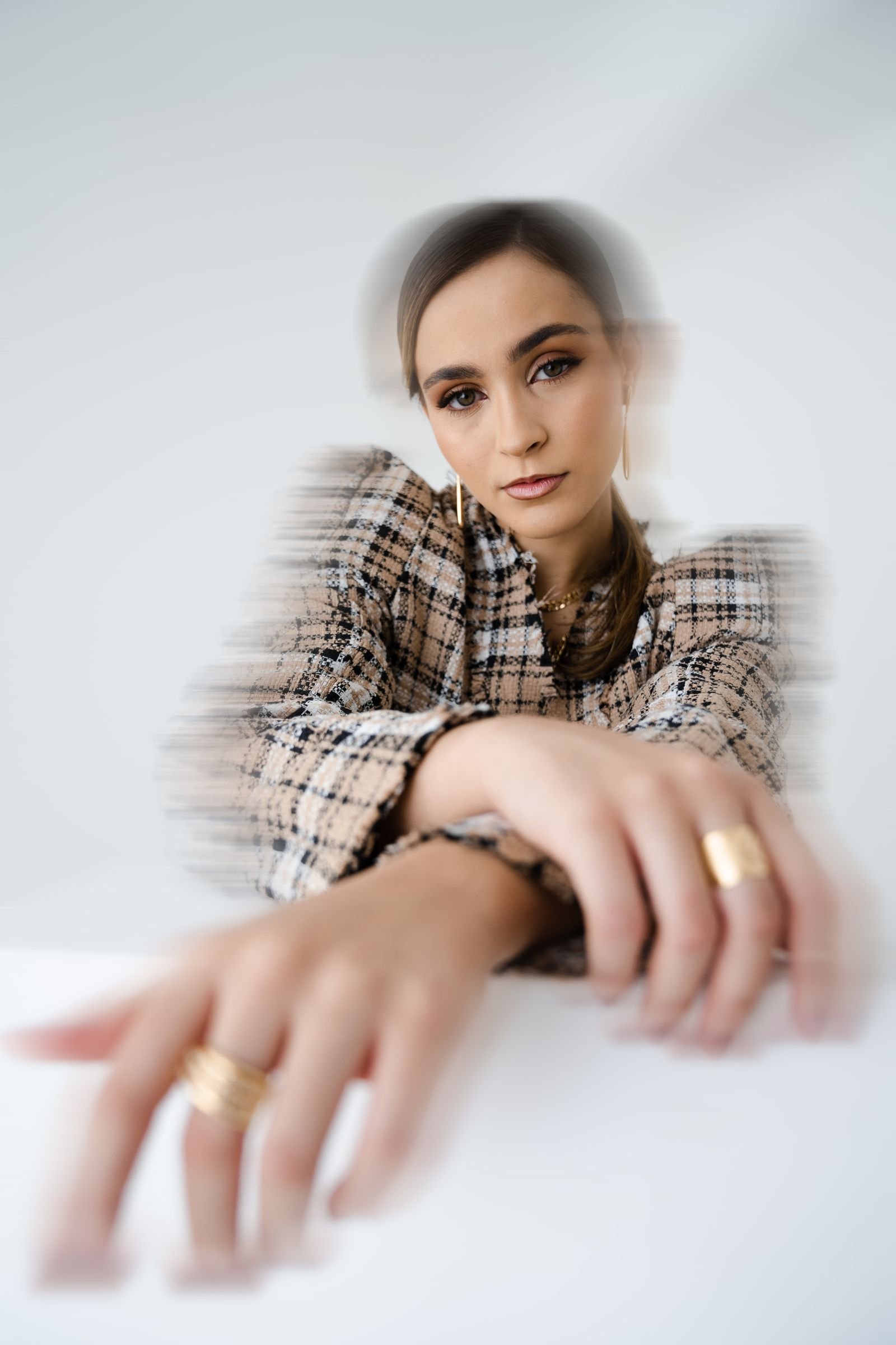 Mujer elegante con anillos grandes de oro, foco en el volumen de las piezas