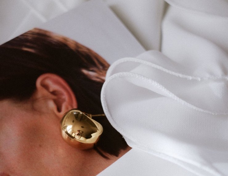 Modelo con arete escultural de oro 18K, estilo editorial