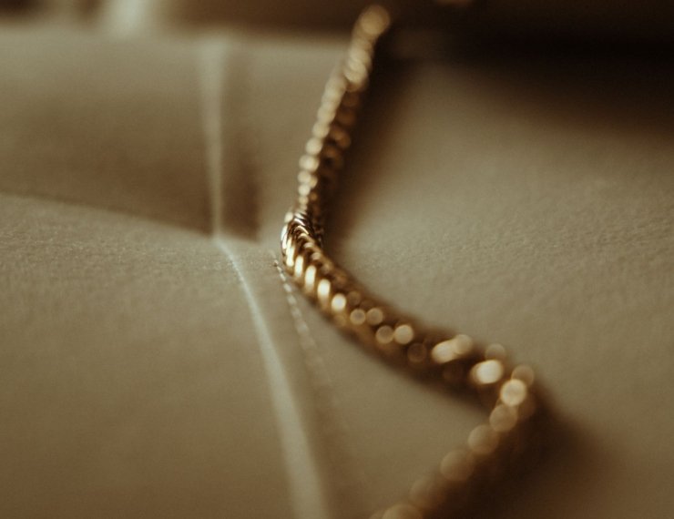 Detalle macro de cadena de oro, textura y brillo del metal