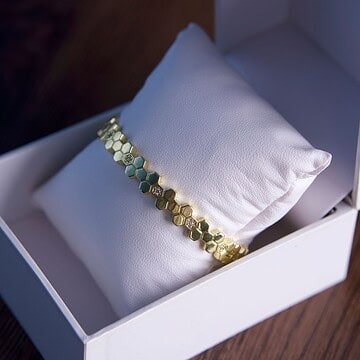 Joya de oro en caja de presentación elegante y moderna.