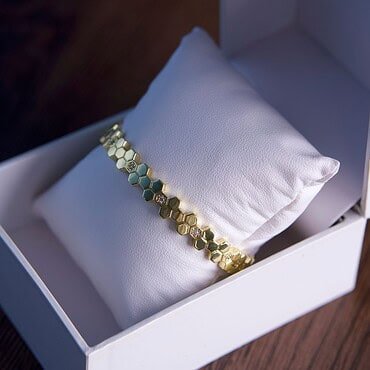 Joya de oro en caja de presentación elegante y moderna.