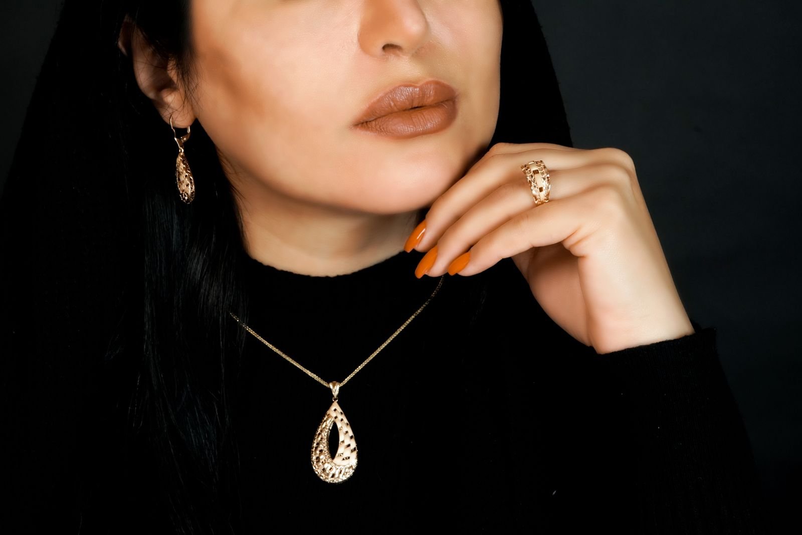 Detalle editorial de joyería de oro 18K sobre modelo, estilo layering