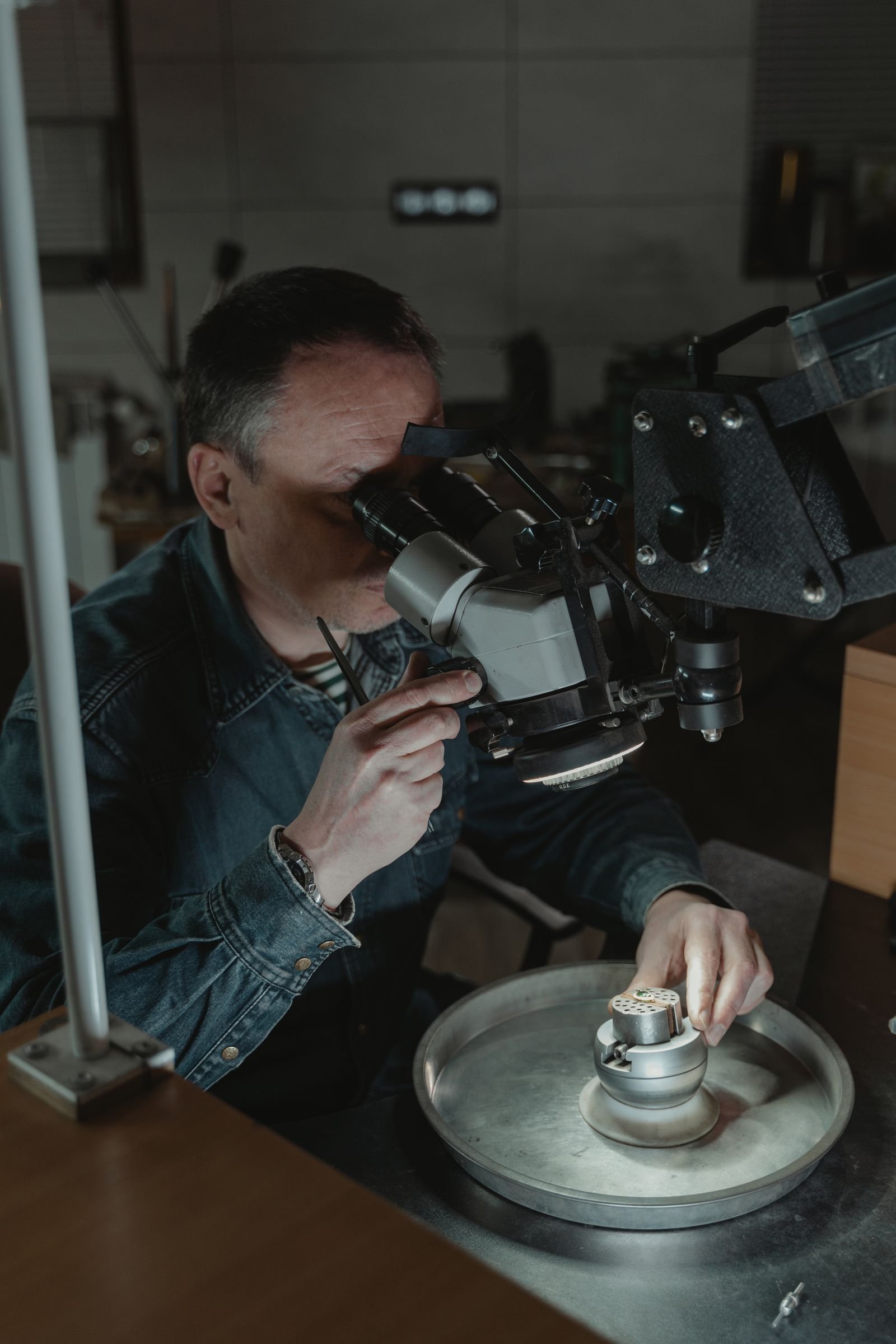 Joyero analizando una pieza de oro con microscopio profesional