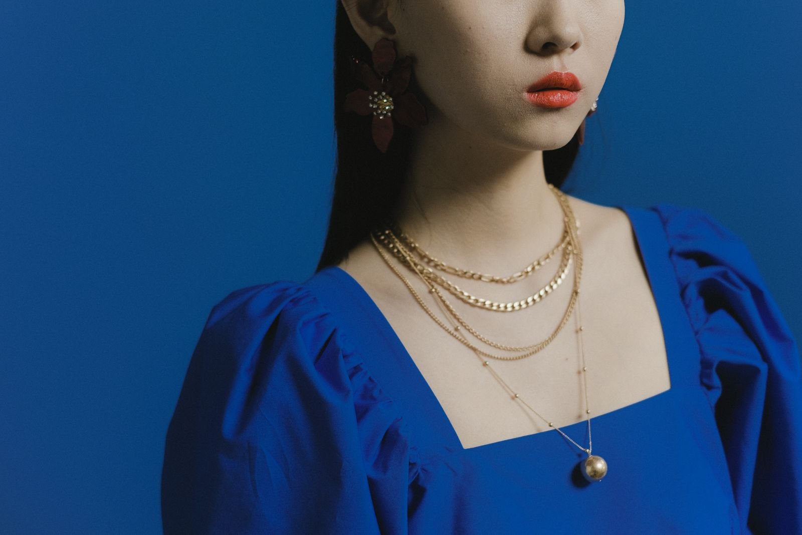 Modelo con collares de oro en capas, distintos largos, estilo editorial elegante