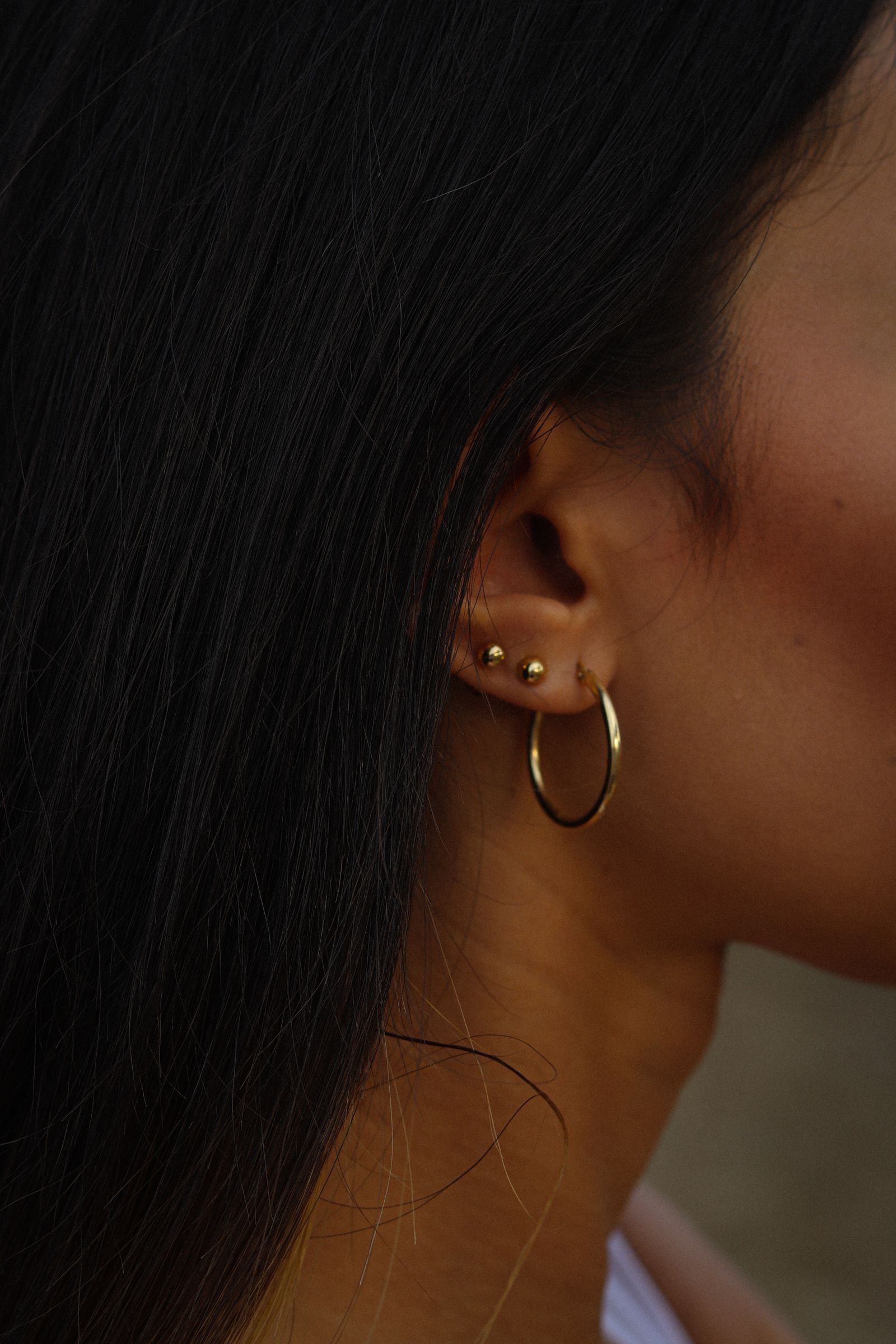 Detalle de piercing pequeño de oro 18K