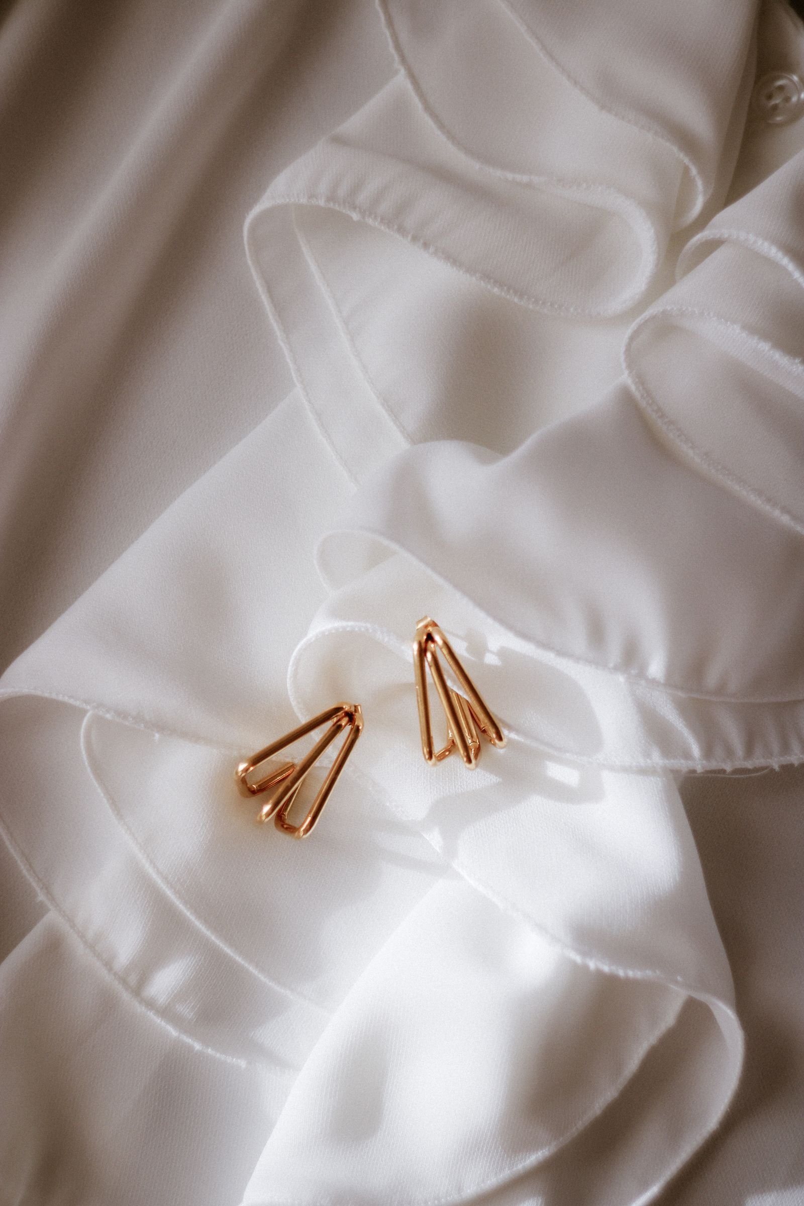 Aretes de oro 18K sobre tela de seda blanca, regalo