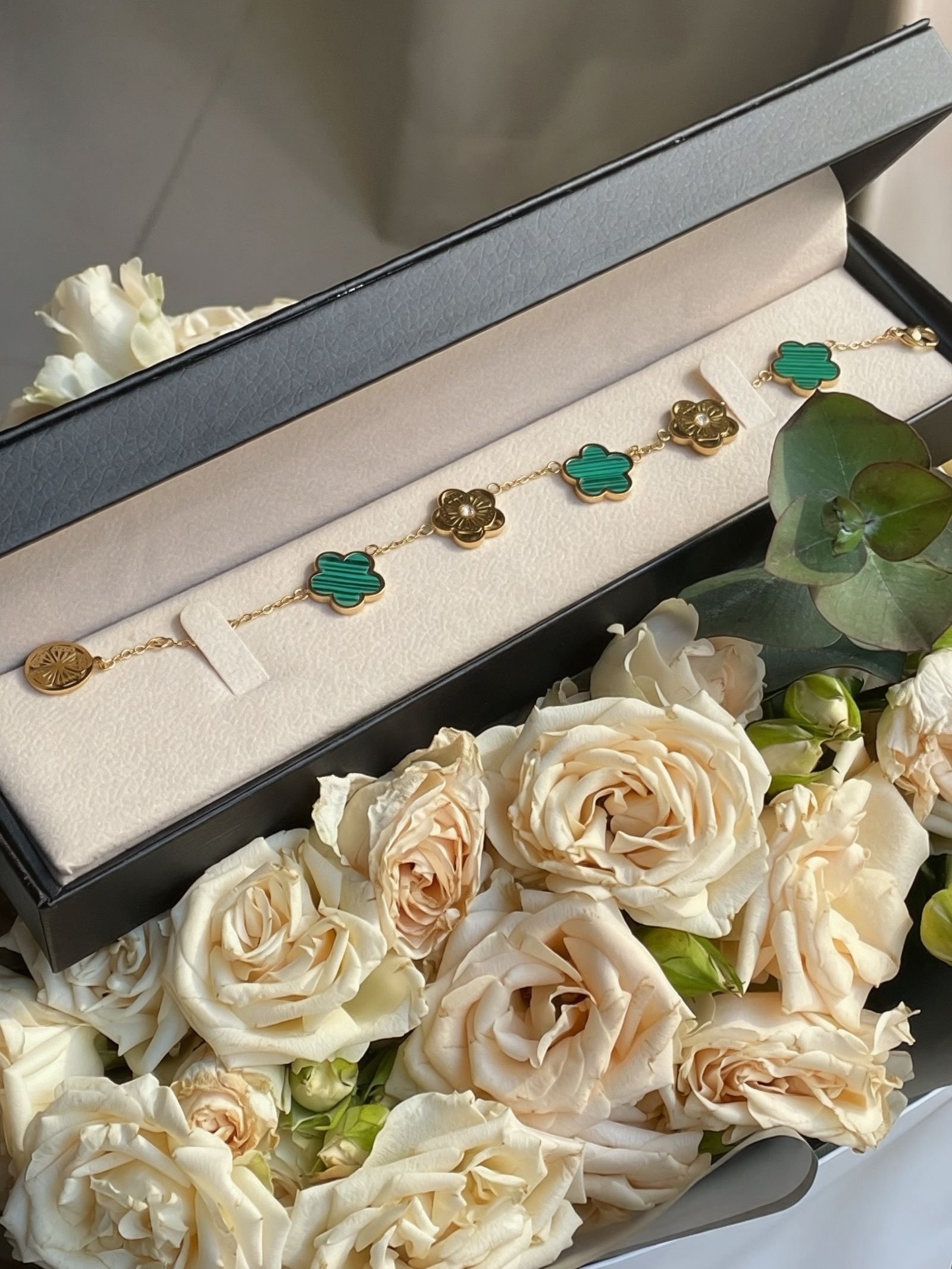 Joyería de oro 18K en estuche elegante rodeado de rosas, guía de regalos