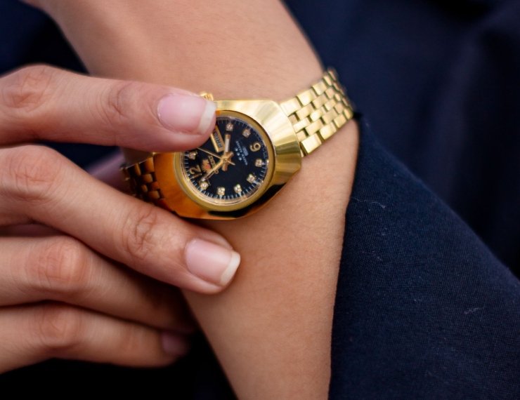 Reloj de oro en muñeca, estilo editorial elegante