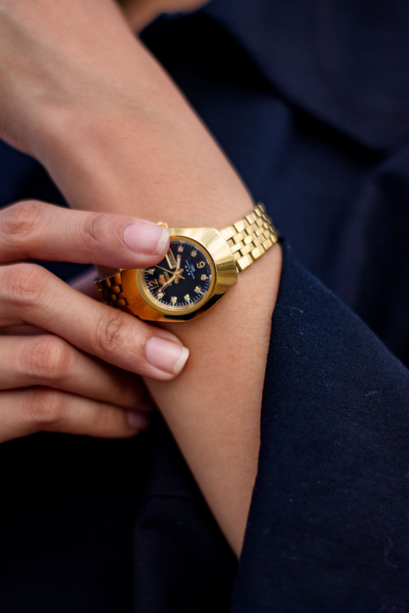 Reloj de oro en muñeca, estilo editorial elegante